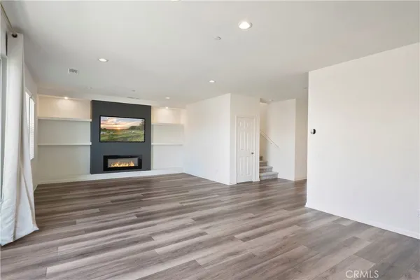 a view of an empty room with a window and fireplace