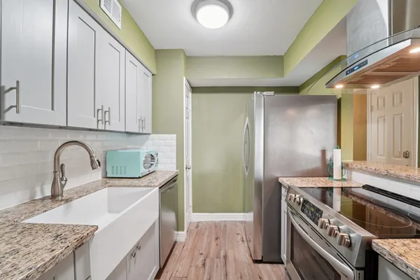 a kitchen with stainless steel appliances granite countertop a sink stove and cabinets