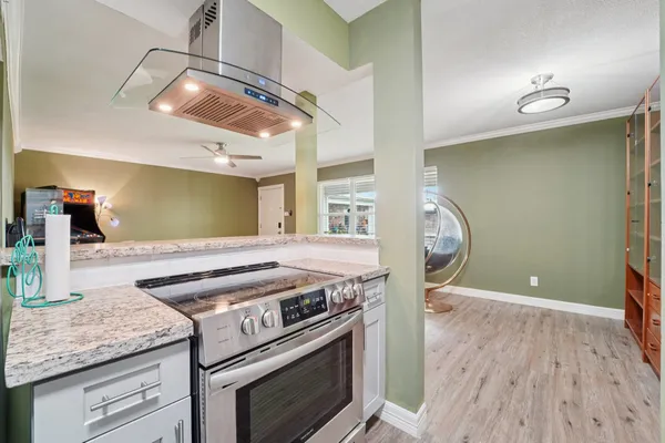 a kitchen with a stove and a wooden floor