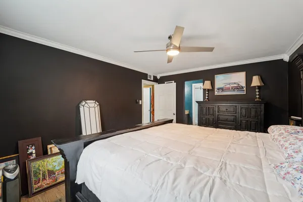 a large bedroom with a bed and wooden floor