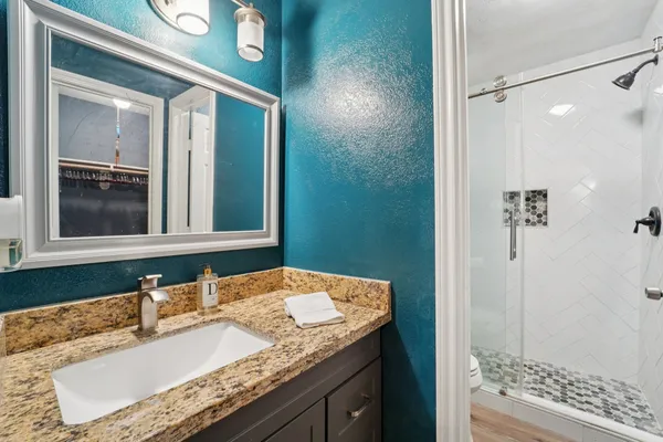 a bathroom with a granite countertop sink and a mirror