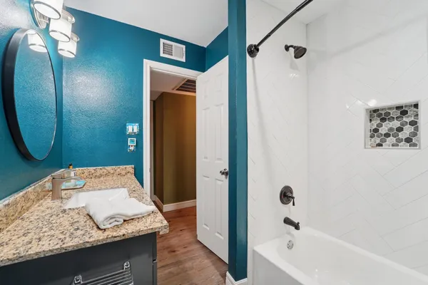 a bathroom with a granite countertop sink and a mirror