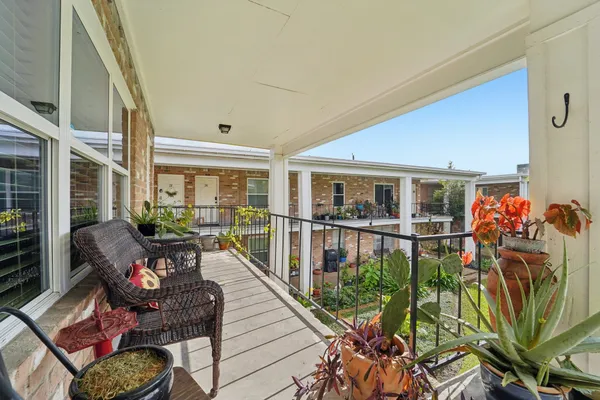 a balcony with furniture and potted plants