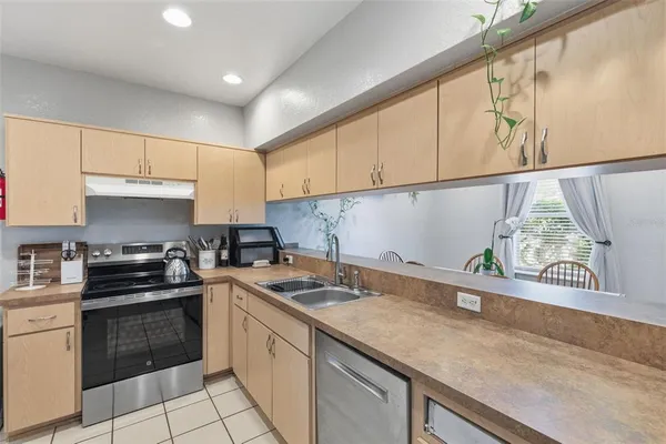 a kitchen with granite countertop a sink a stove and cabinets