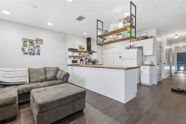 a living room with furniture and kitchen view