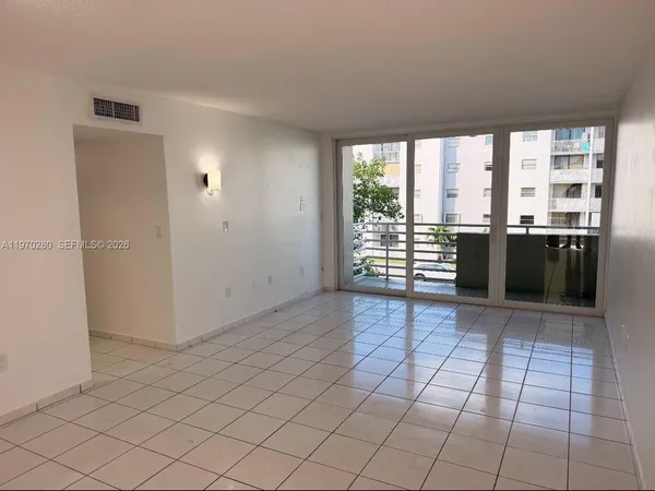 an empty room with chandelier and windows