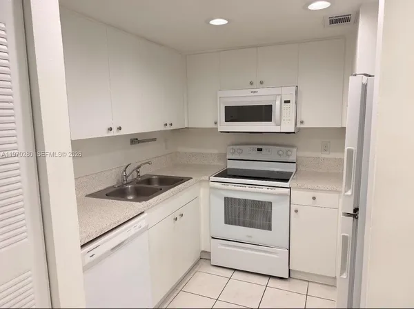 a kitchen with cabinets stainless steel appliances and sink