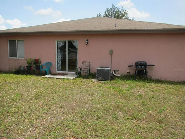 a backyard of a house with barbeque oven and plants