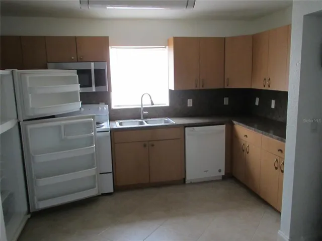 a utility room with cabinets washer and dryer