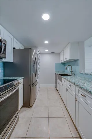 a kitchen with granite countertop a stove top oven and cabinets
