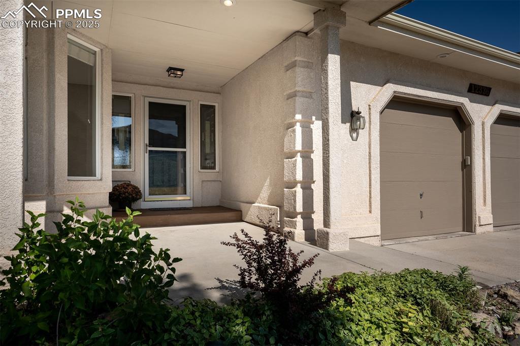 12336 Stanley Canyon Road Colorado Springs, CO 80921 - Photo 5 of 50 Doorway to property featuring stucco siding and a garage