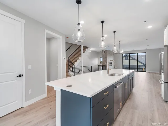 a large kitchen with kitchen island a large counter top stainless steel appliances and cabinets