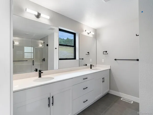a bathroom with a double vanity sink mirror and