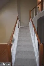 a view of staircase with lots of frames on wall and a window