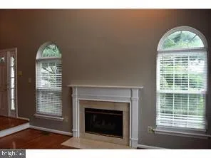 a view of an empty room with a fireplace and a window