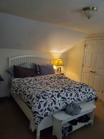 a bed sitting in a bedroom next to a window