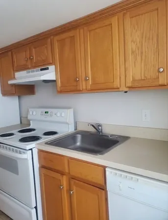 a kitchen with stainless steel appliances granite countertop a sink a stove and cabinets