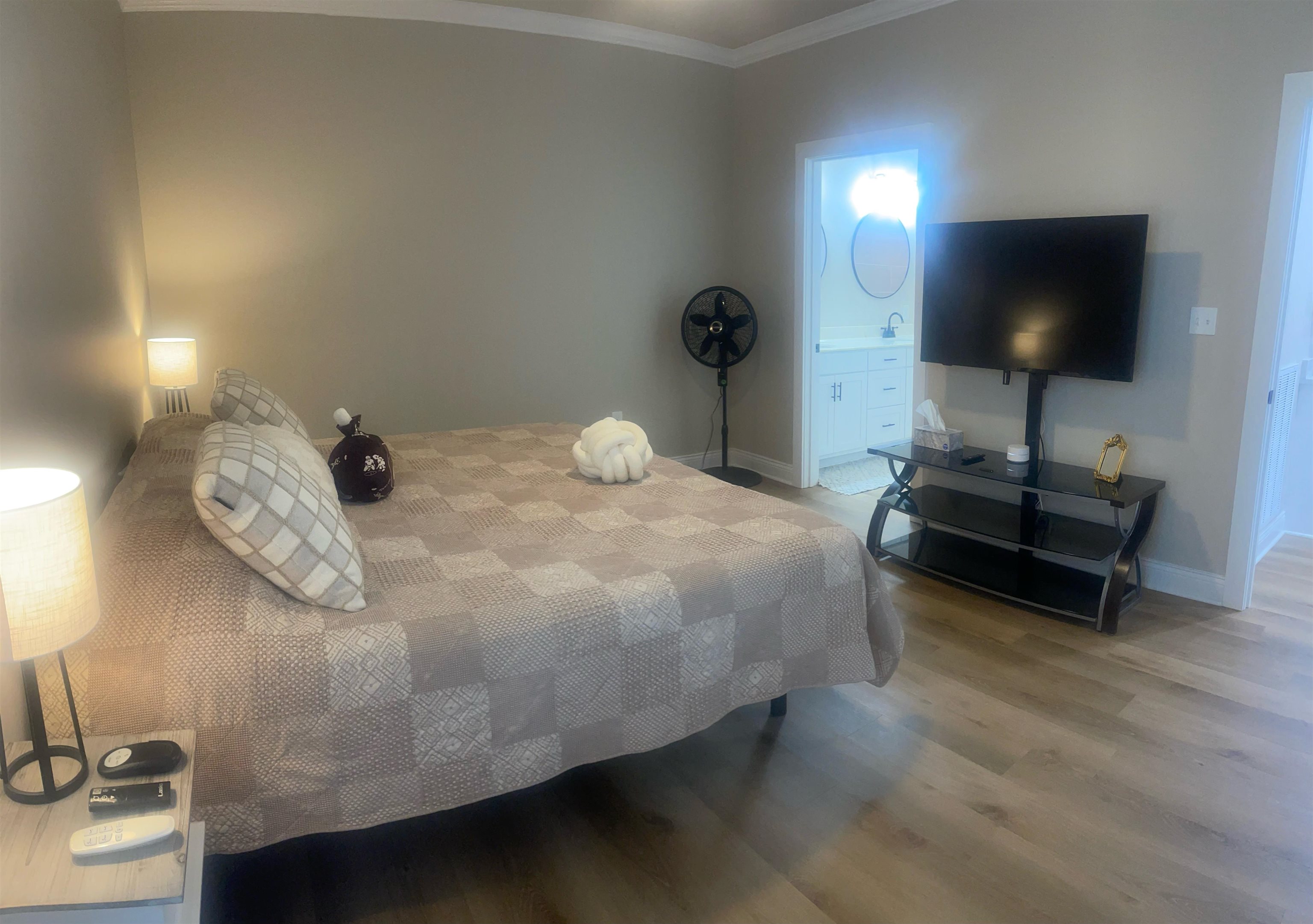 210 Church Street Ripley, TN 38063 - Photo 10 of 21 Neutral wall tones with crown molding, wood-finish flooring, a built-in vanity with under-sink cabinetry, and a circular wall mirror