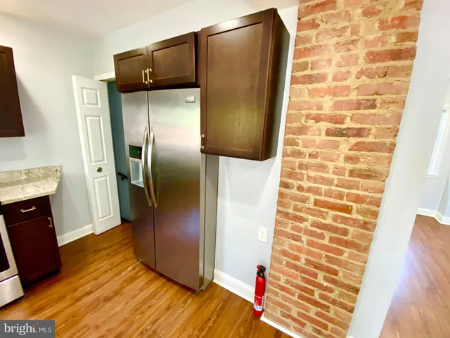 a kitchen with a refrigerator and wooden floor