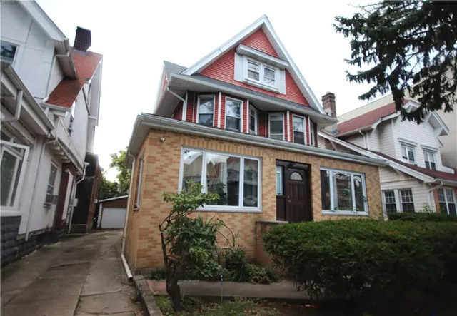 a front view of a house with a garden