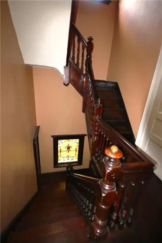 a living room with chairs a dining table and chairs with wooden floor