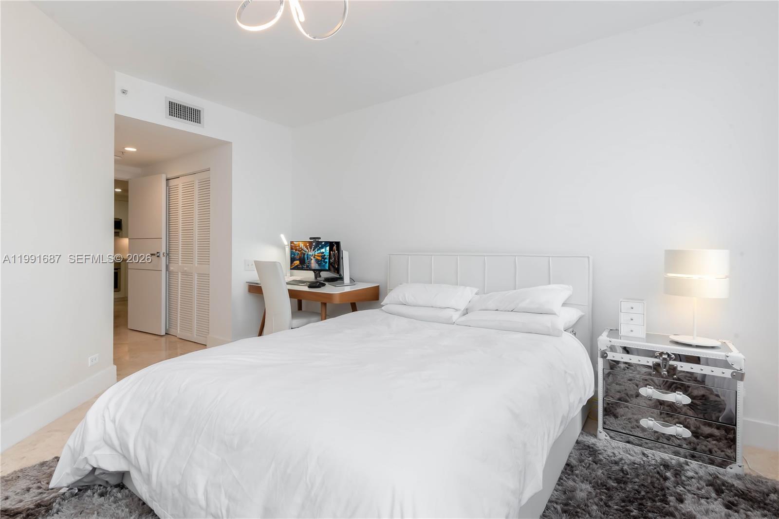 701 Brickell Key Boulevard, Unit 1912 Miami, FL 33131 - Photo 25 of 67 a bed room with a bed and a chandelier