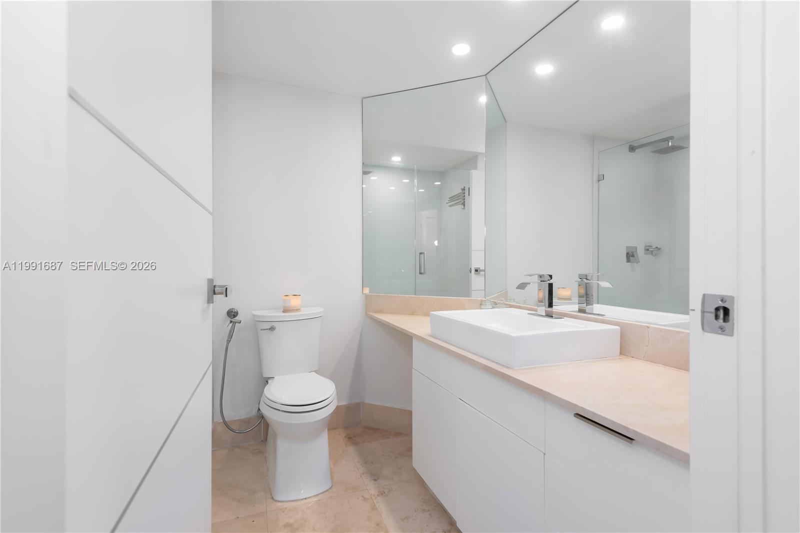 701 Brickell Key Boulevard, Unit 1912 Miami, FL 33131 - Photo 32 of 67 a bathroom with a sink a toilet and a large mirror