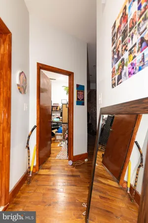 a view of a hallway with wooden floor and a living room