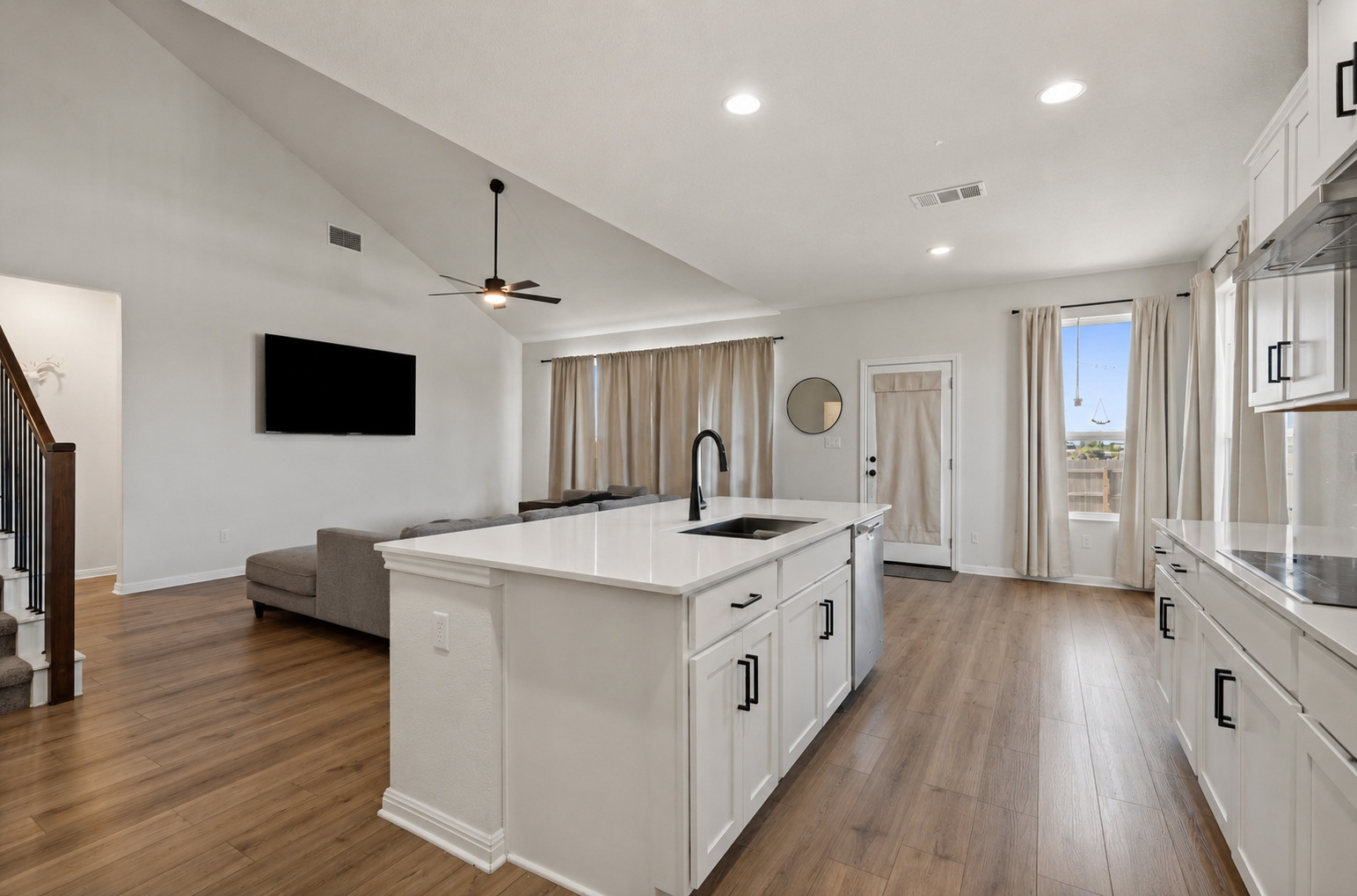 100 Panico Road Hutto, TX 78634 - Photo 8 of 28 Vast ceilings elevate this contemporary kitchen and living area, complete with an inviting island.