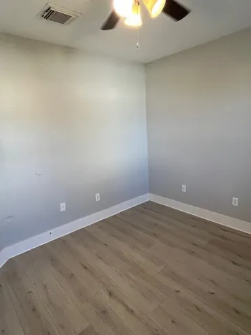 an empty room with a fan and a stove