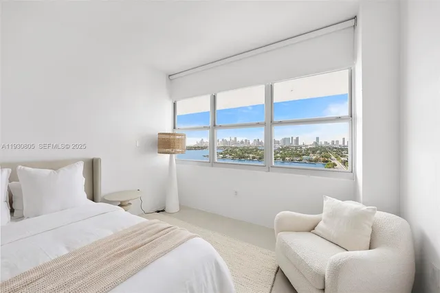 a bedroom with a bed and a large window