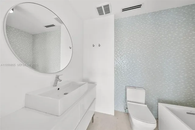 a bathroom with a sink a toilet and a mirror