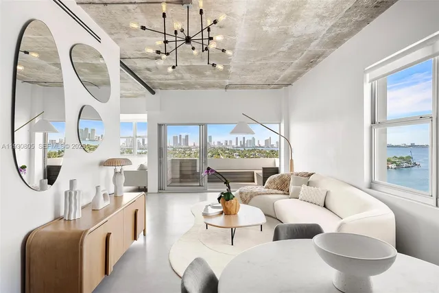 a living room with furniture a chandelier and a large window