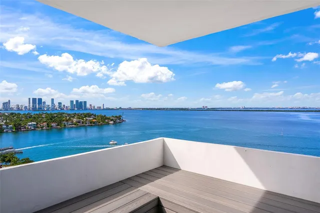 a view of a lake with couches chairs