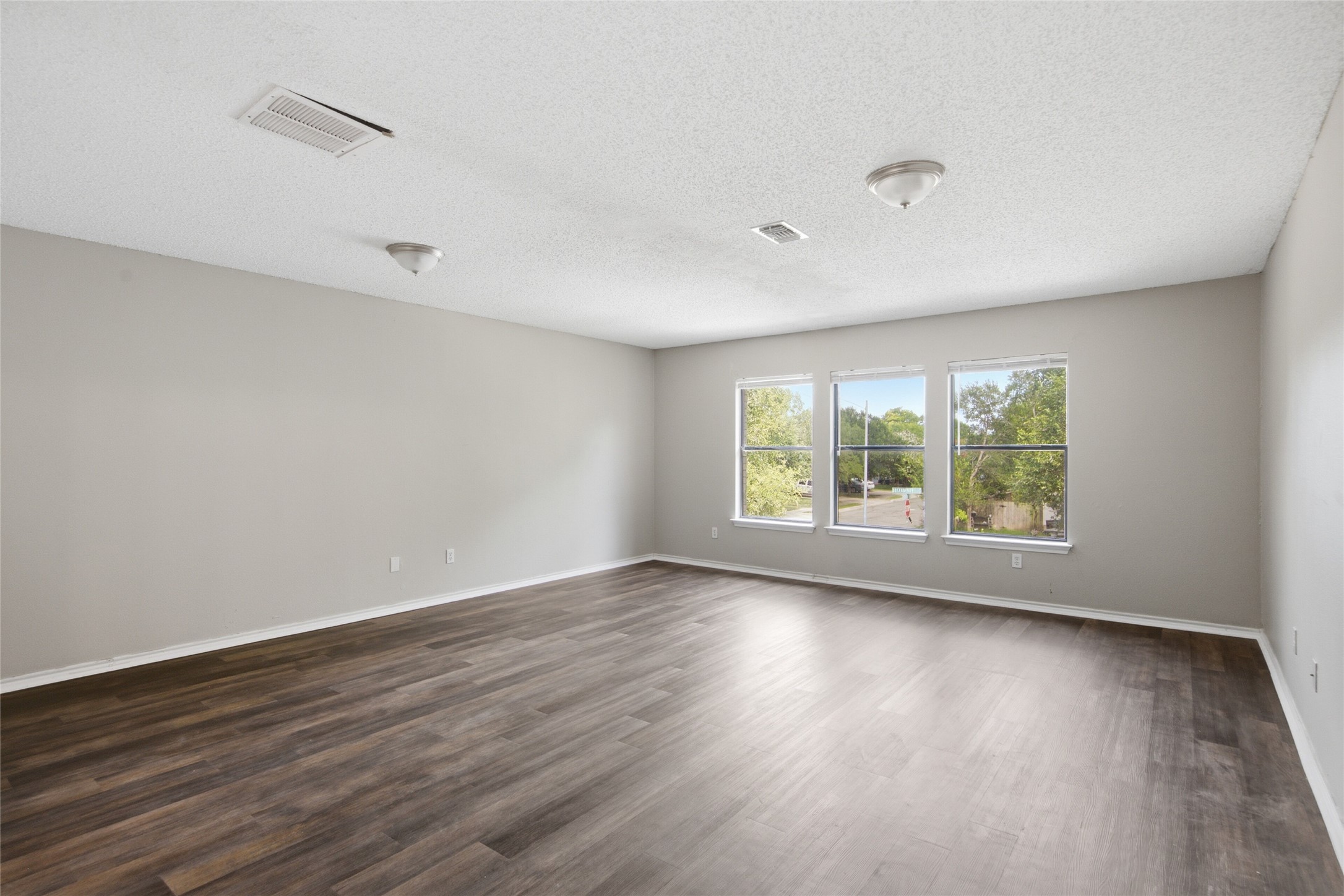7900 Rosenberry Drive Austin, TX 78747 - Photo 19 of 27 A spacious room with abundant natural light from multiple windows and durable laminate flooring.