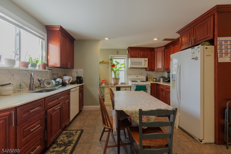 348 Cherry Street Elizabeth, NJ 07208 - Photo 8 of 28 a kitchen with granite countertop a refrigerator a stove a sink a dining table and chairs