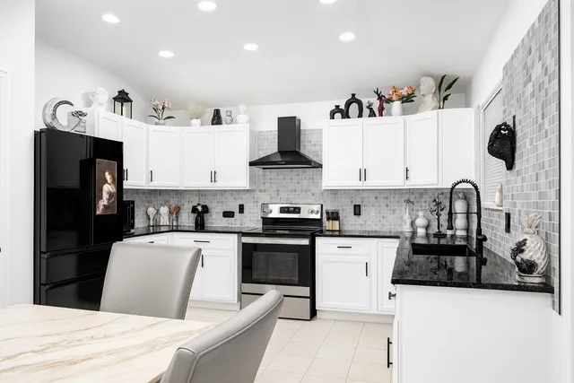 a kitchen with stainless steel appliances granite countertop a refrigerator sink and stove