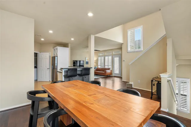 a room with stainless steel appliances kitchen island a table chairs and a kitchen view