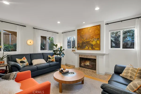 a living room with furniture a fireplace and a large window