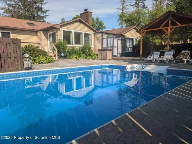 a view of a house with pool and sitting area