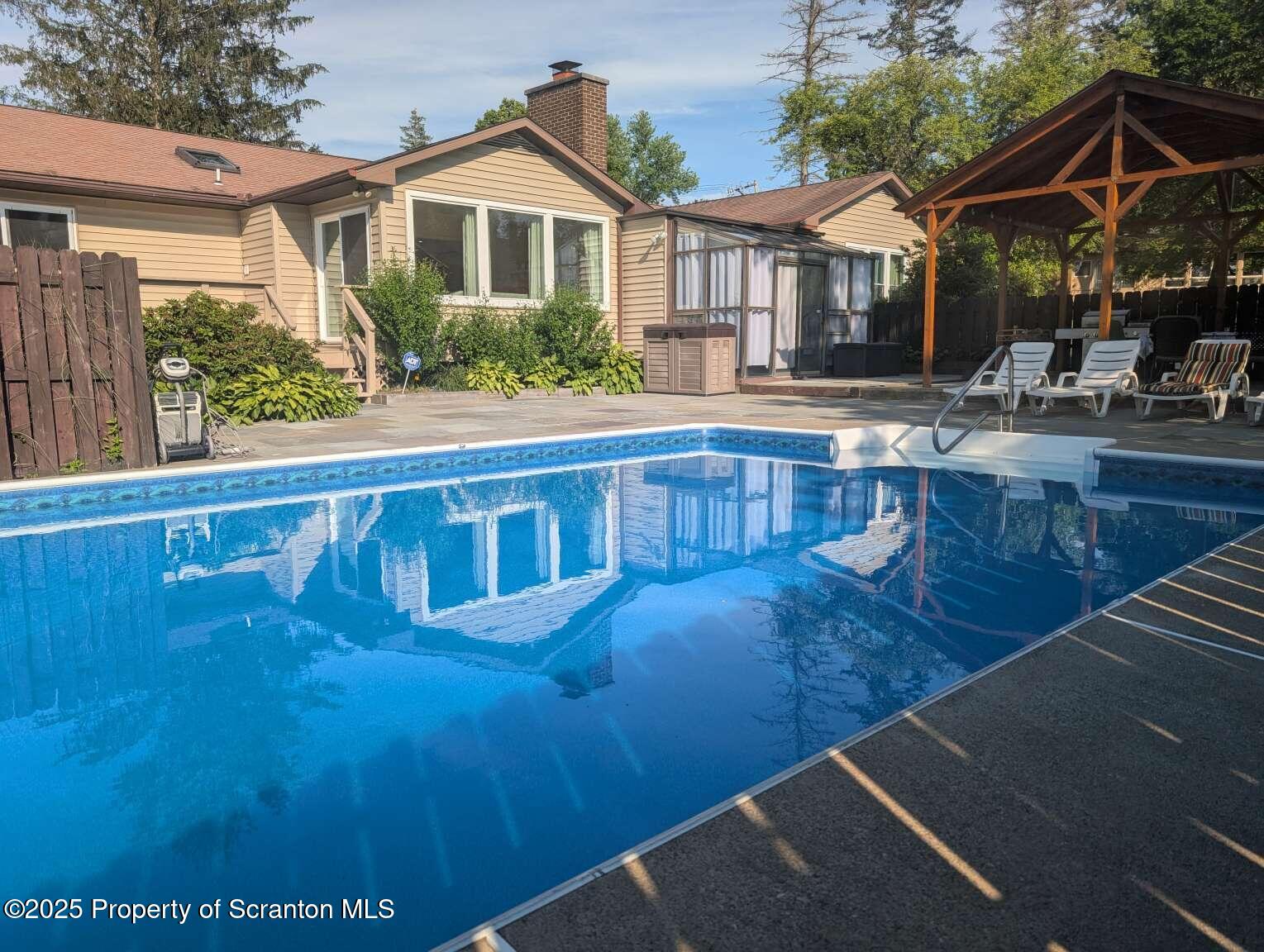 a view of a house with pool and sitting area
