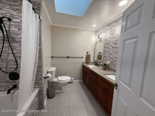 a bathroom with a granite countertop toilet a sink and a mirror