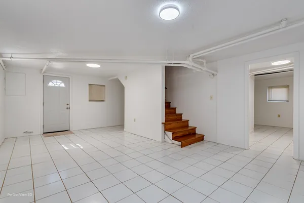 an empty room with stairs and white walls