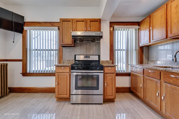 a kitchen with stainless steel appliances granite countertop a stove a sink and a refrigerator