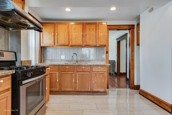 a kitchen with stainless steel appliances granite countertop a stove a sink and a refrigerator