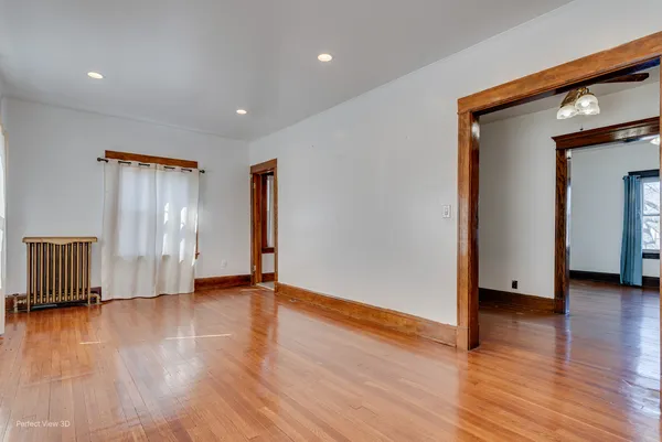 a view of empty room with wooden floor