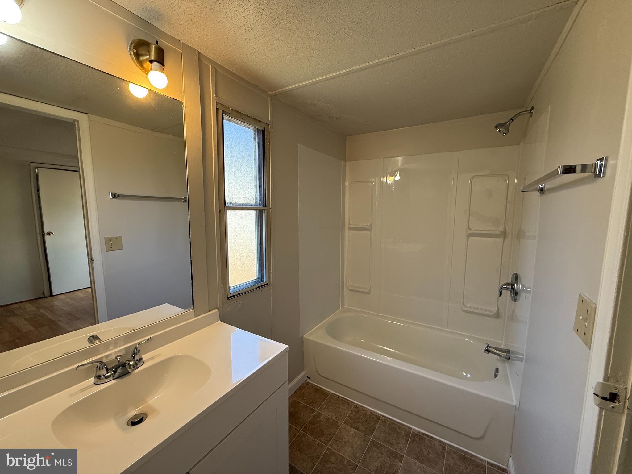 3611 Shirleys Hill Road Partlow, VA 22534 - Photo 14 of 25 a bathroom with a tub a sink and a large mirror