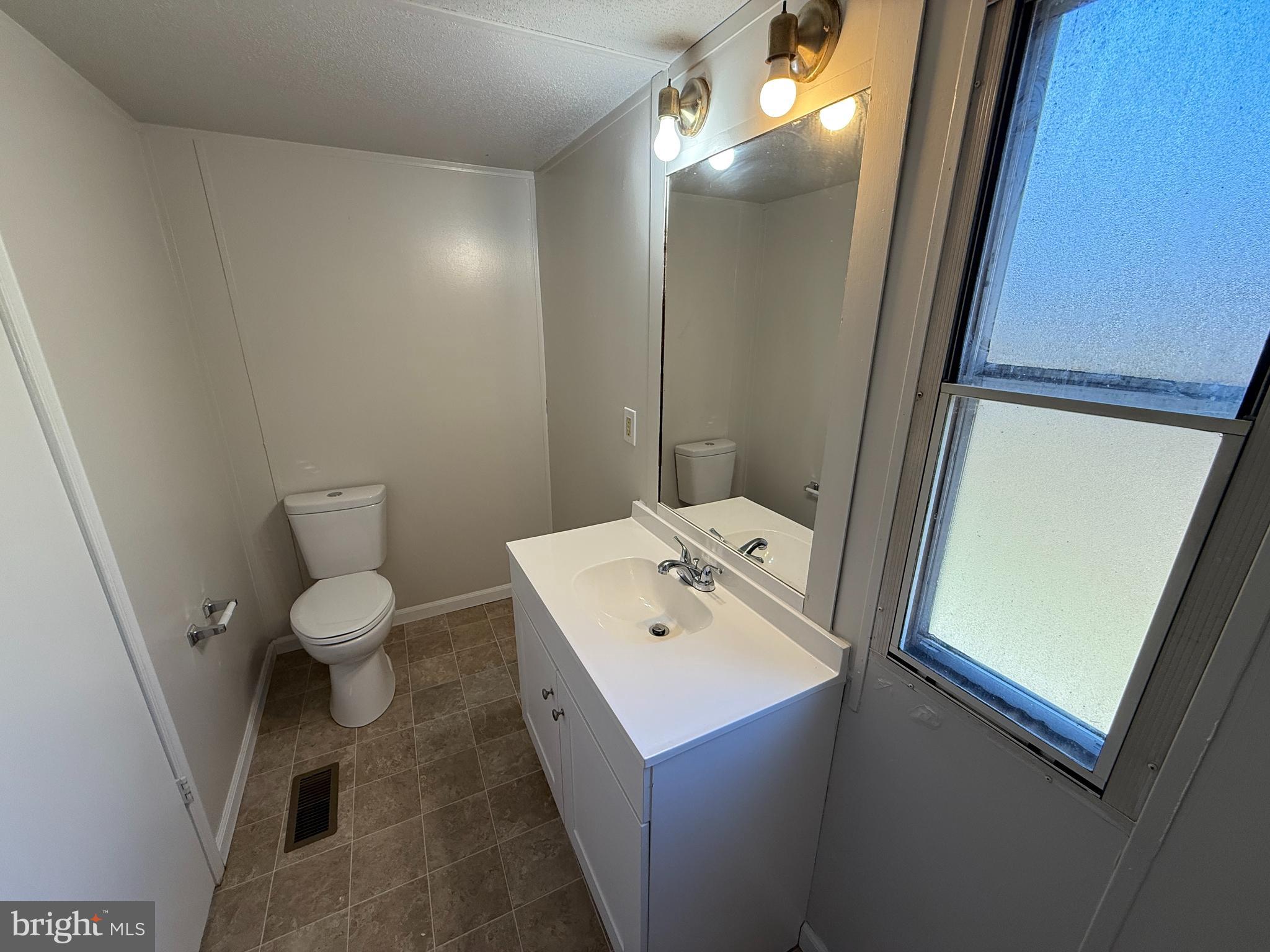3611 Shirleys Hill Road Partlow, VA 22534 - Photo 15 of 25 a bathroom with a toilet a sink and mirror