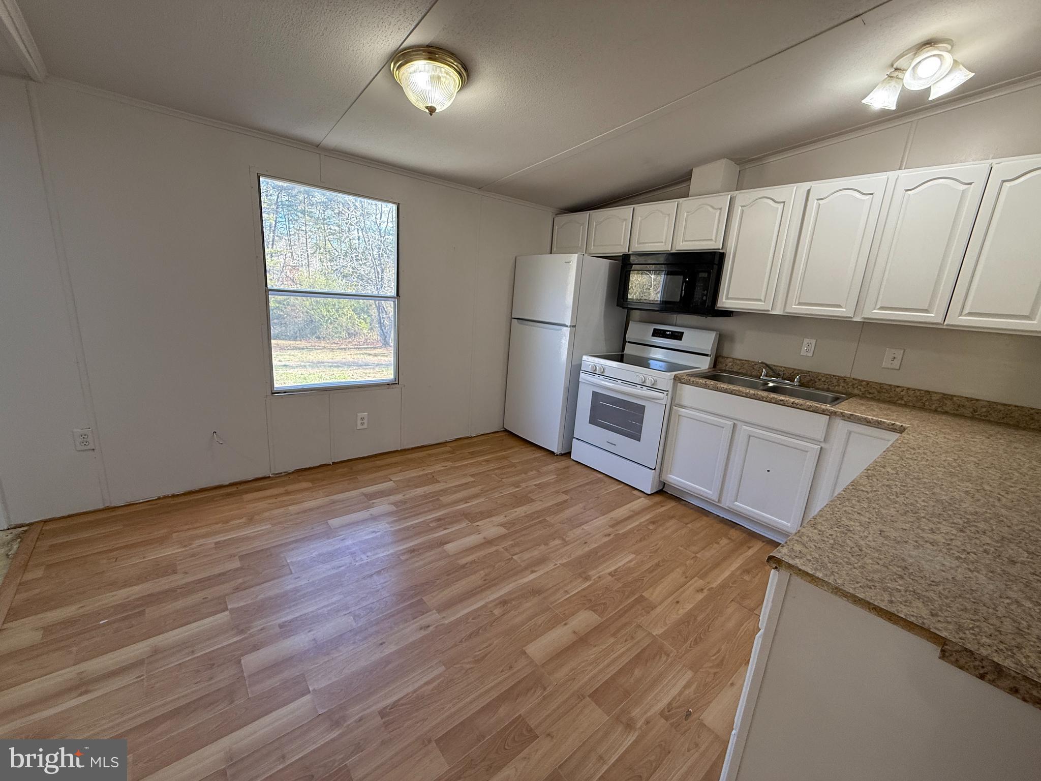 3611 Shirleys Hill Road Partlow, VA 22534 - Photo 19 of 25 a kitchen with granite countertop a stove top oven a sink dishwasher and a refrigerator with wooden floor
