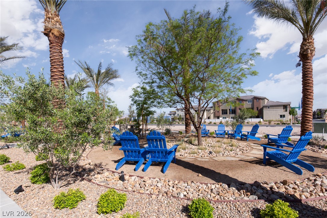 12232 Azure Gate Road, Unit 1 Las Vegas, NV 89183 - Photo 13 of 20 Palm trees and gravel landscaping frame a circular path in a desert community park.